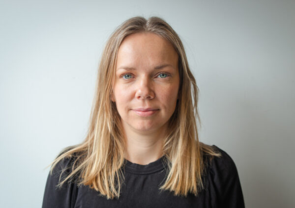 Porträttbild av kvinna med långt ljust hår, ljusa ögon och iklädd en svart tröja