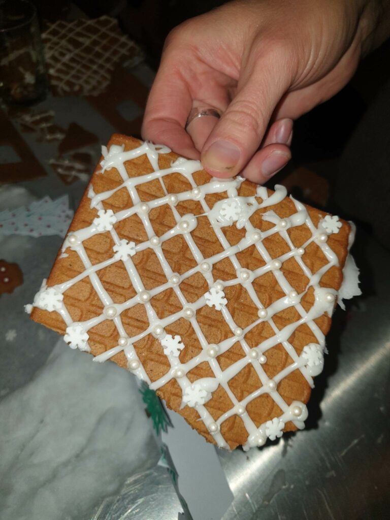 Närbild på taket till ett pepparkakshus med glasyr på