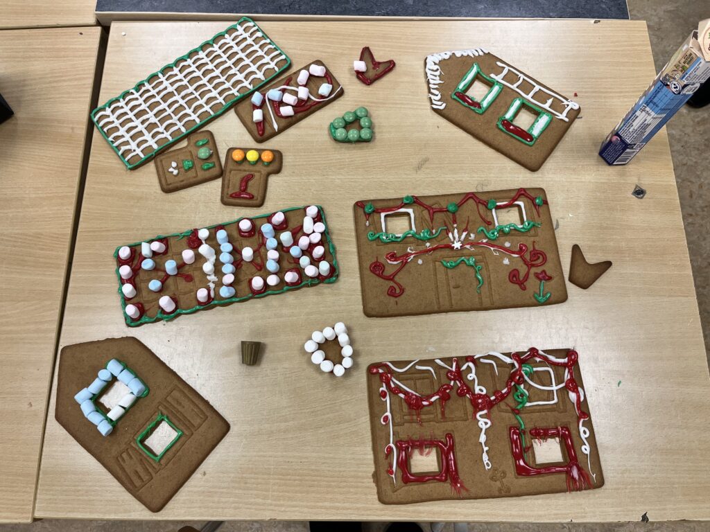 10. Väsby Skola (Uppsala). Bilden föreställer olika icke-sammansatta delar av ett pepparkakshus. Takdelen uppe till vänster i bilden har ett rutnät gjort av vit glasyr, med grön glasyr runt kanterna. Till höger om toppen på bilden finns där en kantvägg med fönster dekorerade i grön, vit och röd glasyr. På kantväggen är det även en stege ditmålad med vit glasyr. På toppen av kantväggen finns där vit glasyr. Runt takdelen finns där hus delar täckta i dekorationer av marshmallows i olika färger, non-stop choklad i olika färger samt röd glasyr.  Takdelen till vänster om mitten av bilden har marshmallows i röd, blå och vit färg fast-klistrat med röd glasyr. 

Höger om mitten av bilden så finns där en husvägg med två fönster, på husväggen är det dekorerat med grön och röd glasyr. 

Längst ner på bilden finns två delar, en kantvägg till vänster som är dekorerat med blå och vita marshmallows runt ett av fönstren, grön glasyr runt kanten på fönstret under. 

Till höger på nedre delen av bilden finns en långvägg som är dekorerad i röd, vitt och grön glasyr. Den röda glasyren är runt fönsterkanterna. 

Delarna ligger allesammans på ett bord.