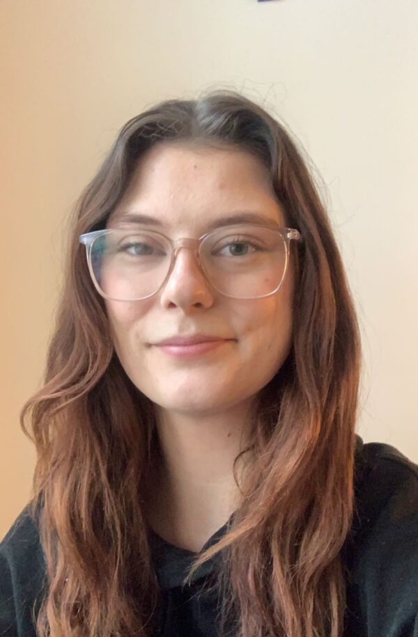 Porträttbild i färg av Greta Gipper som tittar in i kameran och ler.